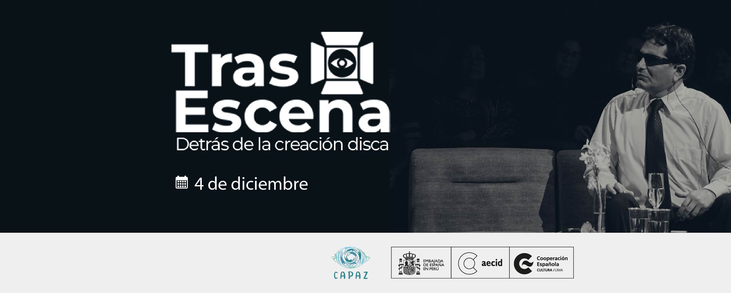 Foto en blanco y nego de un actor ciego, vestido con camisa de mangas largas y corbata, sentado frente a una mesa enn la que hay copas y vasos. Al costado izquierdo se lee TrasEscena, Detrás de la creación disca. Entre las palabras Tras y Escena aparece el dibujo de una cámara de video con un ojo en el medio.