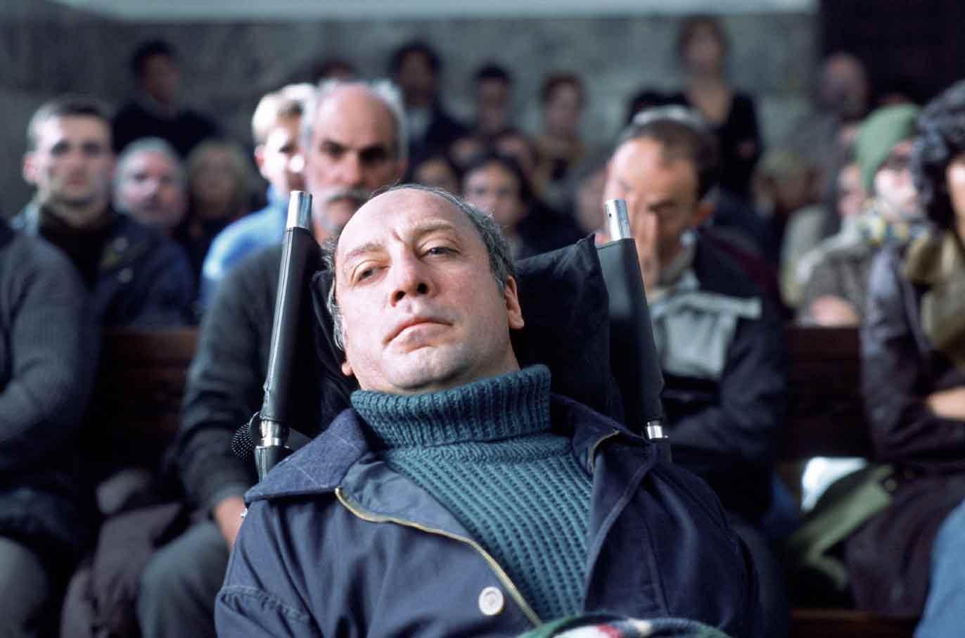 Fotografía de la sala de un juzgado en la que aparece un hombre de unos 50 años, postrado en una silla y mirando muy serio al frente. Detrás de él aparecen muchas personas que observan el juicio.